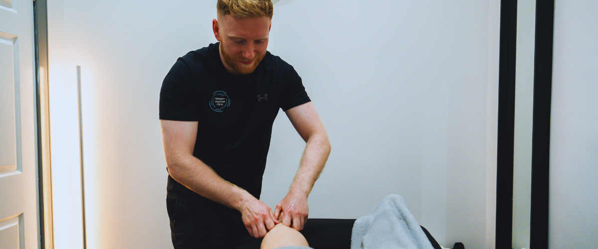 Glasgow Massage Clinic therapist providing a leg massage treatment to a client in a clinic treatment room.